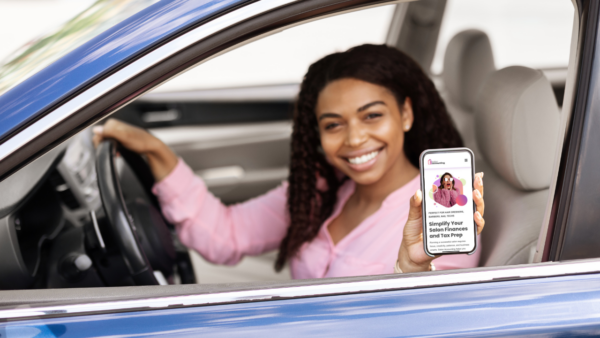 woman holding salon accounting app in car